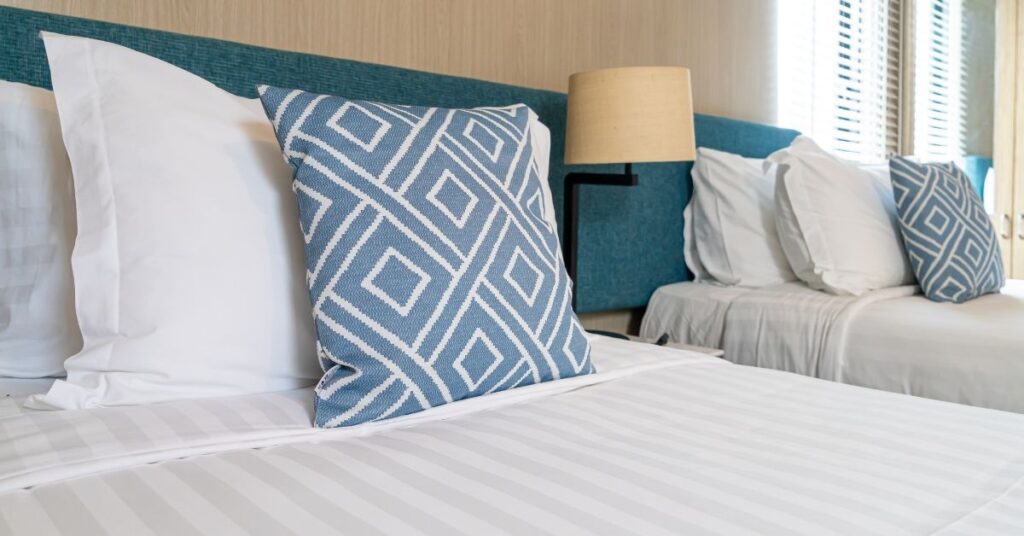 Neat beds with white and blue linen in Fleurieu holiday home.