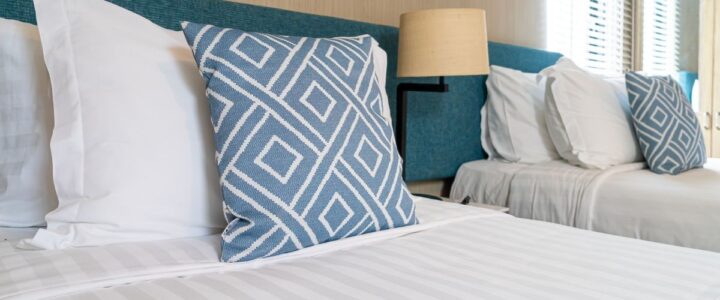 Linen Hire vs Buying Your Own Linen for a Holiday Rental: Which Actually Works Out Better? Neat beds with white and blue linen in Fleurieu holiday home.